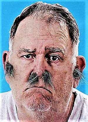 Photograph of man with large tufts of hair growing from his nostrils and his ears.